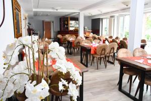 uma sala de jantar com mesas e cadeiras e flores brancas em LANDHAUS LENGEDE Hotel em Lengede
