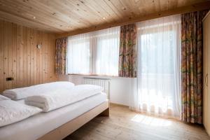 a bedroom with two beds and a large window at Apartments Tino in La Valle