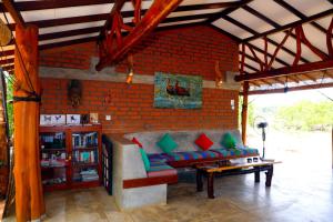 a living room with a couch and a brick wall at The Ibis - Wilpattu in Puttalam