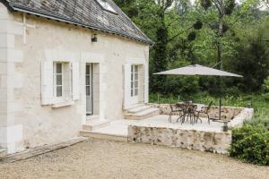 a patio with a table and an umbrella at Country House - La Charbonnière in Continvoir