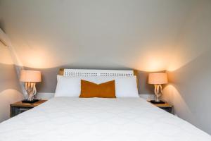a bedroom with a white bed with two lamps at Country House - La Charbonnière in Continvoir +9 photos