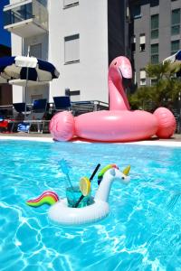 two inflatable flamingos in a swimming pool at Hotel Bristol in Caorle