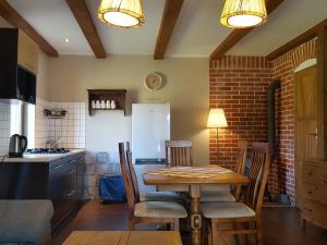 kuchnia ze stołem, krzesłami i lodówką w obiekcie Pokoje i domki Saraceńska Chata w Stegnie