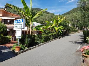a street sign in front of a house with a bar sign at Campeggio Gianna Golfo dei Poeti in Lerici