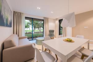 sala de estar con mesa blanca y sillas en OliverLux Aparthotel, en Tihany