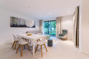 a white dining room with a white table and chairs at OliverLux Aparthotel in Tihany