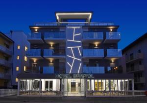 a hotel building with a hotel breakfast sign in front of it at Hotel Bristol in Caorle