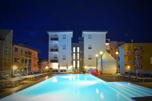 a large swimming pool at night with buildings at Hotel Bristol in Caorle