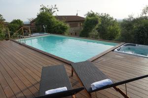 a swimming pool on a wooden deck with two chairs at Casa Lucia in Chianti in Vagliagli