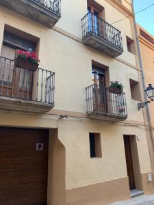 un edificio con balcones y flores en La Caseta del Priorat, en Porrera