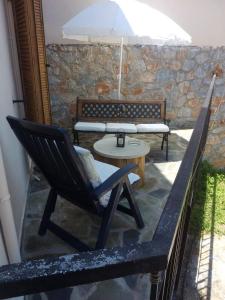 a patio with a chair and a table and an umbrella at Villa Sunrise in Epáno Kefalás