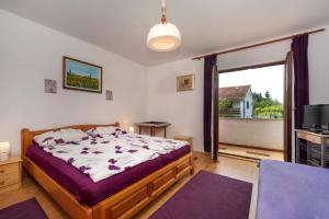 a bedroom with a bed and a tv and a window at Apartments Villa Elena in Poreč