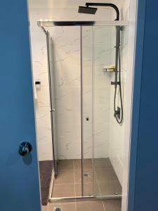 a shower with a glass door in a bathroom at Branxton House Motel in Branxton