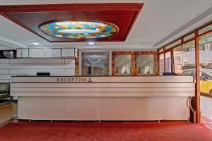 a restaurant with a reception counter in a room at Bharati Lodge in Hubli