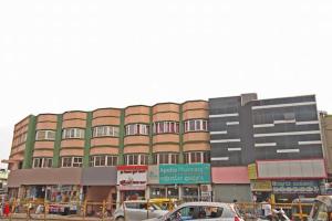 un gran edificio con coches estacionados frente a él en Bharati Lodge en Hubli