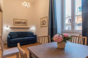 uma sala de estar com uma mesa e um sofá azul em CS Termini Nazionale Apartments em Roma