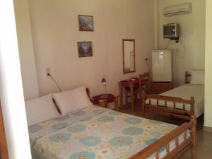 una camera con 2 letti, un tavolo e un frigorifero di Asprovalta Rooms a Kariotes