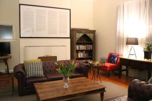 een woonkamer met een bank en een tafel bij Nyima Tashi Buddhist Centre in Auckland