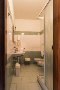 a bathroom with two toilets and a sink and a shower at Hotel Jollino in Pineto