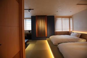 a bedroom with two beds and a desk in it at Kashoutei Hanaya in Noboribetsu +128 photos