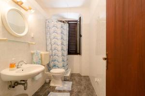 a bathroom with a sink and a toilet and a mirror at Rooms Mozara in Trsteno