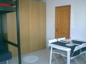 Zimmer mit einem Tisch und einem Etagenbett in der Unterkunft STUDIO CLIMATISE. Proche parking, commerces et mer in Carqueiranne