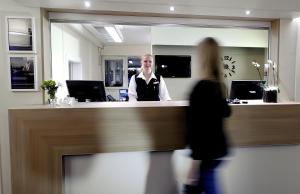a man standing behind a counter in an office at Good Morning Mölndal in Mölndal
