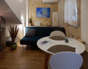 a living room with a table and a blue couch at Apartments Infinitas in Trogir