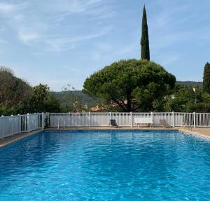 a large swimming pool next to a white fence at Villa Soledad in Cassis