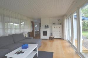 ein Wohnzimmer mit einem Sofa und einem Tisch in der Unterkunft Rosenborgs Friluftspensionats stugor med kök in Färjestaden