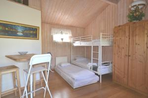 a room with two bunk beds and a desk at Rosenborgs Friluftspensionats stugor med kök in Färjestaden