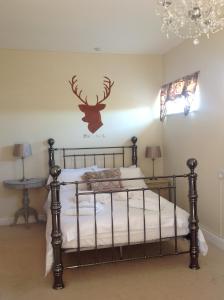 a bedroom with a bed with a deer on the wall at Hooray Henrys in Sheringham