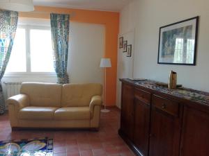 salon z kanapą i oknem w obiekcie Casa Monaco w mieście Auletta