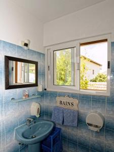 a bathroom with a sink and two windows at Apartment Mrgudic in Orebić