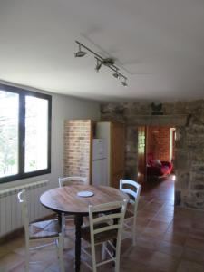 a kitchen and dining room with a table and chairs at Gîte Le Petit Nid in Portes +11 photos