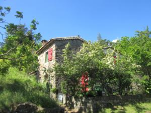 an old stone house on a hill with trees at Gîte Le Petit Nid in Portes