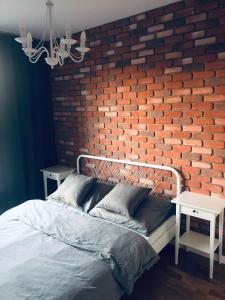 a bedroom with a brick wall and a bed at Lofty & Apartamenty Garnizon Gdańsk in Gdańsk