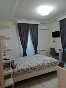 a bedroom with a bed and a desk and a television at B&B FLAVIO in Pozzuoli