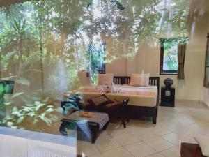 una camera con un letto e una grande finestra di Prasanti Bed & Breakfast ad Ubud