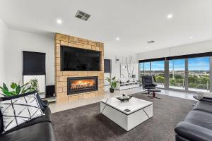 a living room with a fireplace and a couch at KENNEDY EXECUTIVE TOWNHOUSE in Mount Gambier
