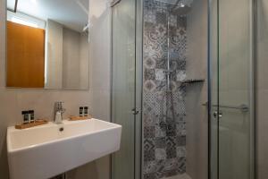 un baño con lavabo y ducha en Acropolis View Hotel, en Atenas