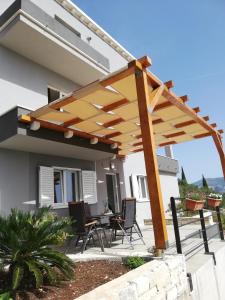 a wooden pergola on a patio of a house at Apartman Andrea in Korčula +8 photos