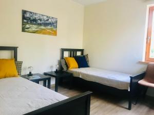 Habitación con 2 camas y almohadas amarillas y azules. en Family apartment 100m from the beach, en Jūrmala