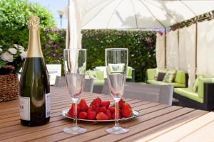 una mesa con una botella de vino y un plato de fresas en New Opening Villa Oasis Terramar, en Sitges