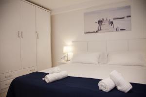una camera da letto bianca con due asciugamani su un letto di New Opening Villa Oasis Terramar a Sitges Altre 29 foto