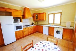 a kitchen with wooden cabinets and a white refrigerator at Marques - holiday home with private swimming pool in Benitachell in Benitachell