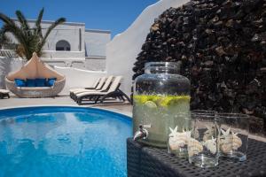 un pot en verre assis sur une table à côté d'une piscine dans l'établissement Irene City Villas, à Fira