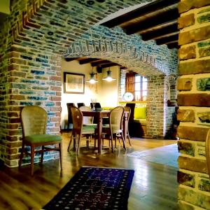 uma sala de jantar com mesa e cadeiras e uma parede de tijolos em Xenonas ton Chromaton em Lafkos