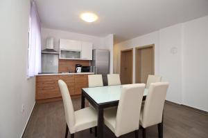 cocina y comedor con mesa y sillas en Apartments Smojver Stipe en Baška