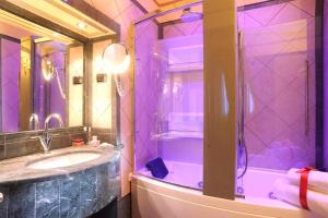 een paarse badkamer met een wastafel en een douche bij Hotel Manfredi Suite In Rome in Rome